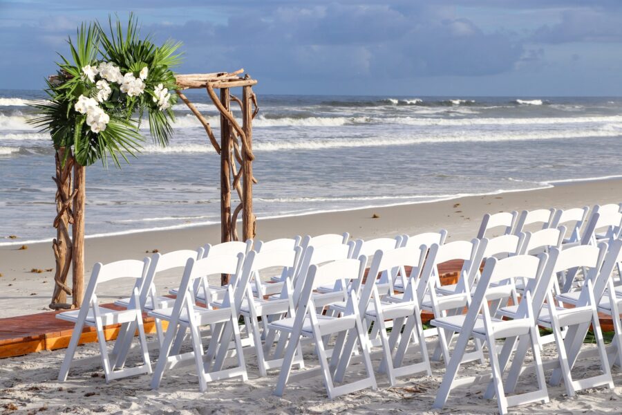 Beach-Wedding-With-White-Chairs-And-Wooden-Arch